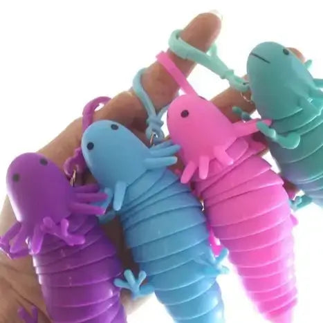 a finger holding a purple, blue, pink, and green axolotl fidget toy on a clip