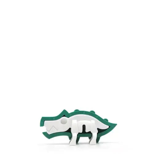 plastic half of the green crocodile shows the white plastic skelton inside.