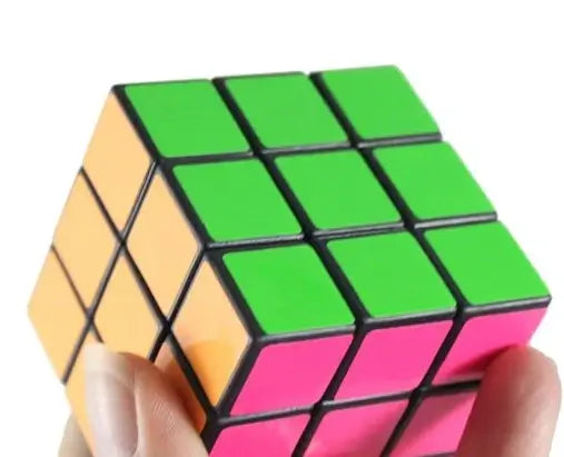 a hand holding a neon rubik cube showing the green, pink, and orange side