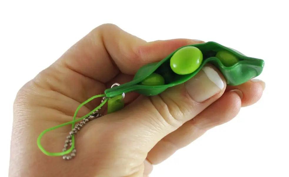 a hand pushing a tiny pea out of the pea pod fidget